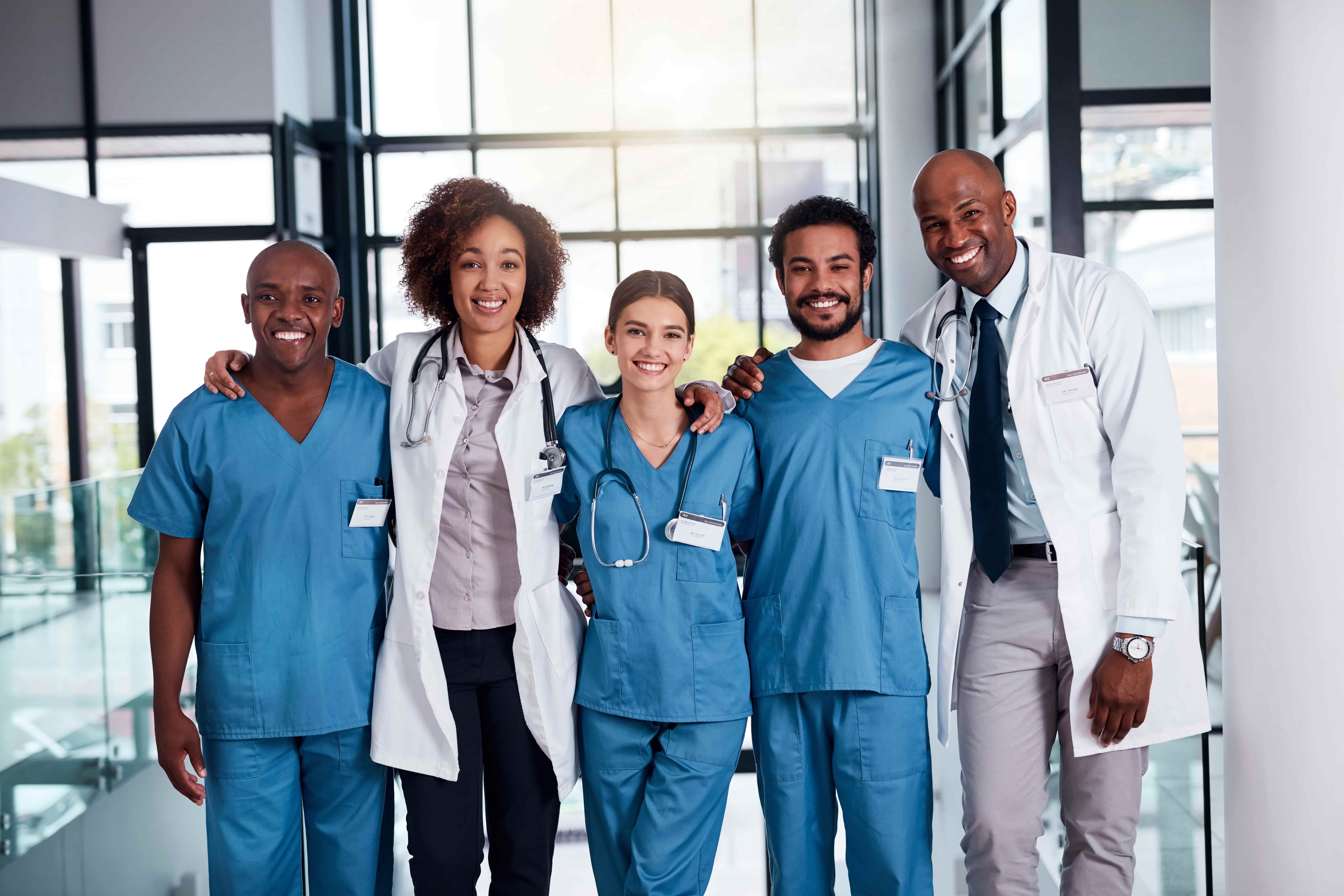 A group of smiling healthcare workers in a hospital.